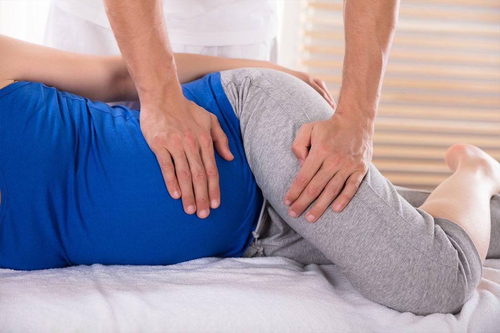 pregant woman recieving a chiropractic adjustment for lower back and pelvic pain